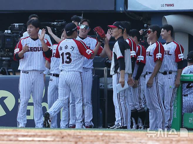 [서울=뉴시스] 배훈식 기자 = 22일 오후 서울 송파구 잠실야구장에서 열린 2025 신한 쏠뱅크 KBO리그 LG 트윈스와 두산 베어스의 경기, 2회까지 무실점한 LG 송승기가 동료들과 하이파이브를 하며 덕아웃으로 들어가고 있다. 2025.06.22. dahora83@newsis.com