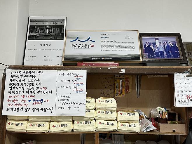 가게 한켠 세워진 찬장에는 손 글씨로 쓴 가격 인상 안내문이 붙어 있다. /단정민기자