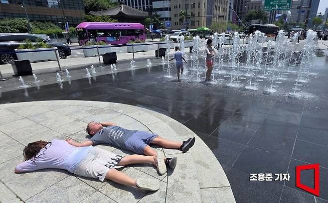 낮 최고기온이 33도를 웃돌고 후텁지근한 날씨가 이어진 지난 19일 서울 종로구 광화문광장 분수대를 찾은 아이들이 물놀이를 즐기고 있다. 조용준 기자