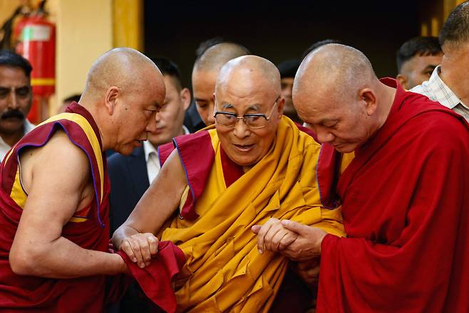 티베트의 정신적 지도자 달라이 라마가 지난 4일 망명정부가 있는 다람살라에서 수행자들의 부축을 받고 있다./AFP 연합뉴스