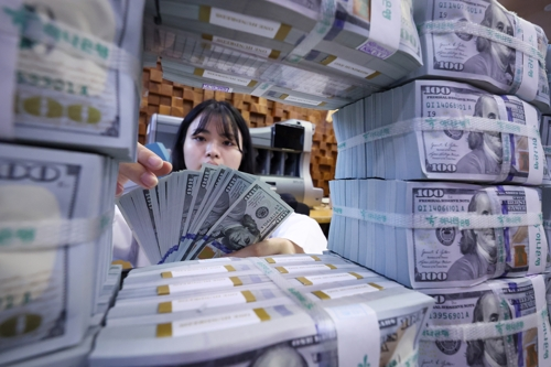 은행 관계자가 외화를 정리하는 모습. [사진 출처 = 연합뉴스]