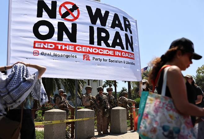 시위대가 미국의 이란 핵 시설 공격에 항의하는 가운데 미 해병대가  캘리포니아주 로스앤젤레스의 연방 건물에서 경비를 서는 모습[로이터]