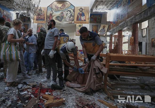 [다마스쿠스=AP/뉴시스] 시리아 민방위 대원들이 22일 다마스쿠스 외곽 드웨일라 지구에 있는 그리스정교 교회에서 발생한 자폭테러 사건 직후 현장에 출동해 시신을 수습하고 잔해물을 치우고 있다. 2025.06.23