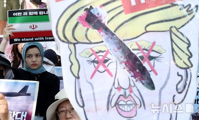 [서울=뉴시스] 추상철 기자 = 트럼프 미국 대통령이 이란의 주요 핵 시설을 파괴했다고 밝힌 22일 오후 서울 종로구 교보빌딩 인근에서 열린 노동자연대의 '전쟁 중단 및 이스라엘 공격 규탄집회'에서 이란인 등 집회 참가자가 피켓을 들고 전쟁 중단을 촉구하고 있다. 2025.06.22. scchoo@newsis.com