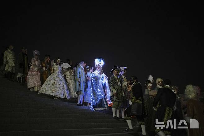 [베르사유=AP/뉴시스] 21일(현지 시간) 프랑스 파리 베르사유 궁전 오랑주리에서 열린 가면 무도회에 참가한 참가자들이 이동하고 있다. 2025.06.23.