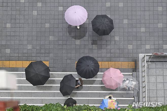 [광주=뉴시스] 박기웅 기자 = 장맛비가 내린 18일 점심 식사를 마친 광주 북구청 직원들이 청사로 복귀하고 있다.  2024.07.18. pboxer@newsis.com