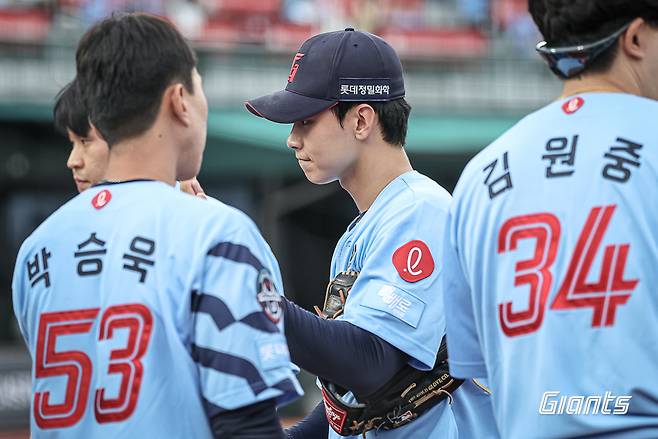 롯데 자이언츠 홍민기가 22일 부산 사직야구장에서 열린 삼성 라이온즈와의 홈경기에서 이닝을 막아낸 뒤 동료들의 응원을 받으며 더그아웃으로 들어가고 있다. 롯데 자이언츠