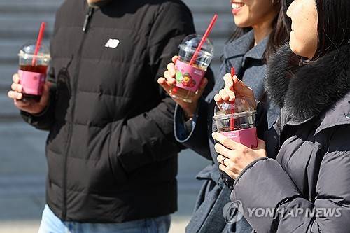 커피   (서울=연합뉴스) 서대연 기자 = 광화문광장에서 시민들이 차가운 커피를 마시며 이동하고 있다. 2025.3.6 dwise@yna.co.kr