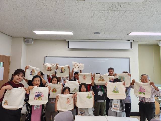 ▲ '세대공감 놀이터 프로그램에 참여한 청주 덕벌초 학생들과 청주내덕노인복지관 어르신들이 패브릭 가방을 만들었다./덕벌초 제공