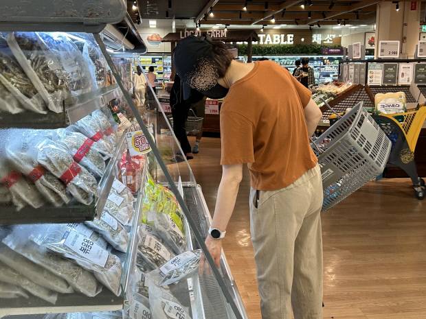 지난 23일 광주광역시의 한 대형마트에서 한 주부가 식자재의 가격표를 비교하고 있다. 윤준명 기자