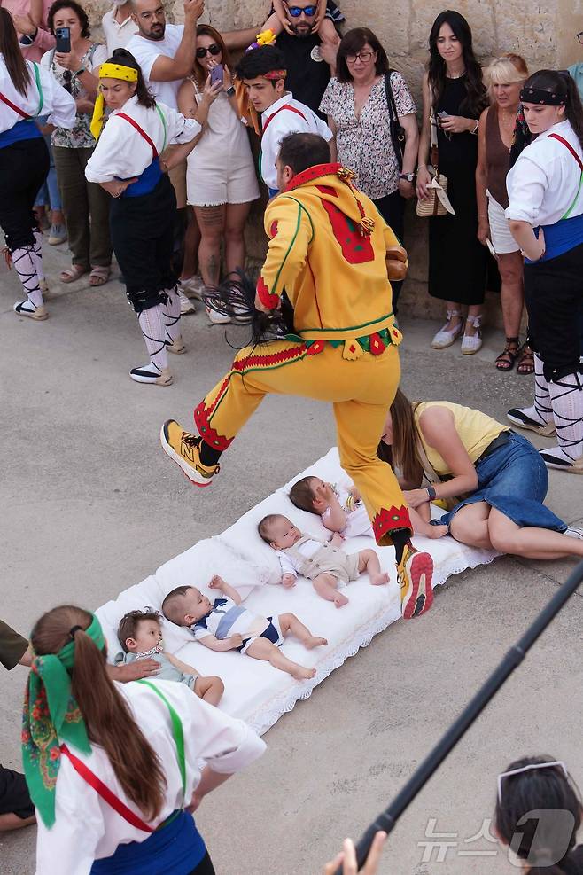22일(현지시간) 스페인 부르고스 인근 카스트리요 드 무르시아 마을에서 열린 '엘 콜라초(El Colacho)'축제에서 악마를 상징하는 '콜라초'가 아기들을 뛰어넘고 있다.ⓒ AFP=뉴스1