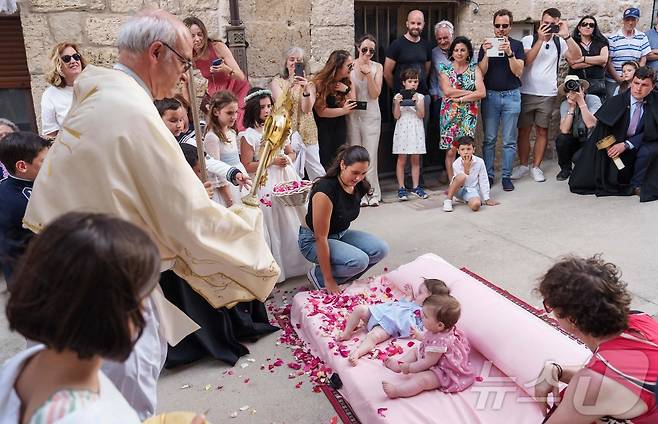 22일(현지시간) 스페인 부르고스 인근 카스트리요 드 무르시아 마을에서 열린 '엘 콜라초(El Colacho)'축제에서 성직자가 아이들을 축복하고 있다. ⓒ AFP=뉴스1