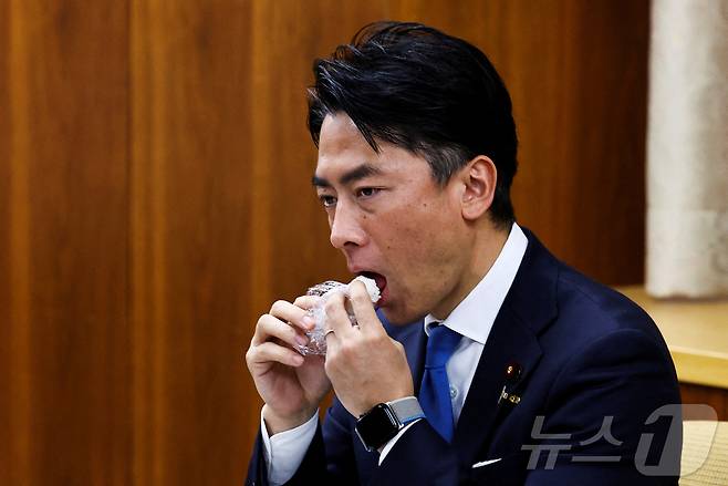 고이즈미 신지로 일본 농림수산상이 28일 도쿄 시식 행사에서 정부 비축미로 만든 주먹밥을 먹고 있다. 2025.05.28 ⓒ 로이터=뉴스1 ⓒ News1 최종일 선임기자