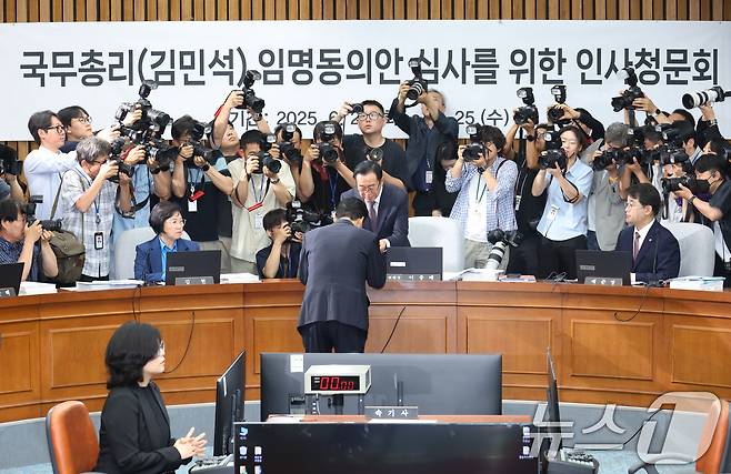 김민석 국무총리 후보자가 24일 오전 서울 여의도 국회에서 열린 인사청문회에 출석해 이종배 위원장에게 선서문을 전달하고 있다. 2025.6.24/뉴스1 ⓒ News1 이광호 기자