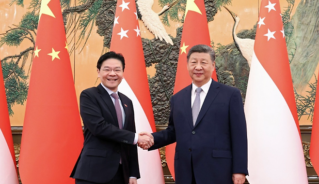 24일 중국 베이징에서 시진핑(오른쪽) 중국 국가주석과 로런스 웡 싱가포르 총리가 악수하고 있다. ⓒ로이터/연합뉴스