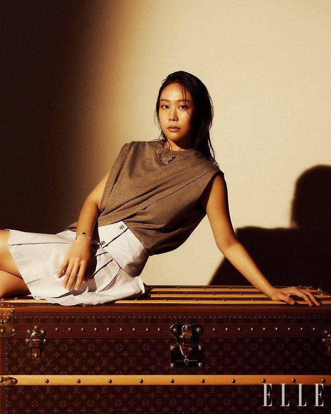 슬리브리스 티셔츠와 스트라이프 포플린 스커트, 오닉스와 다이아몬드를 세팅한 옐로골드 컬러 블라썸 BB 멀티 모티프 브레이슬릿, 가죽 핸들이 달린 말 쿠리에 110 트렁크는 모두 Louis Vuitton.