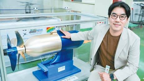 홍도관 박사가 ‘50kW급 비접촉 마그네틱 기어 적용 상반회전 프로펠러’ 옆에서 포즈를 취하고 있다. 상반회전 프로펠러는 단일 프로펠러보다 추진 효율이 10% 이상 높다. [사진 한국전기연구원]