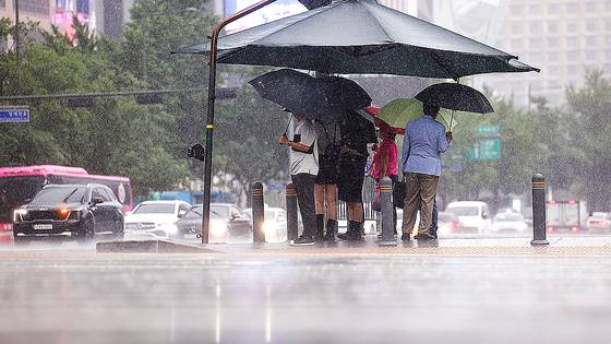 지난 20일 서울 종로구 광화문 네거리에서 우산을 쓴 시민들이 신호를 기다리고 있다. 연합뉴스