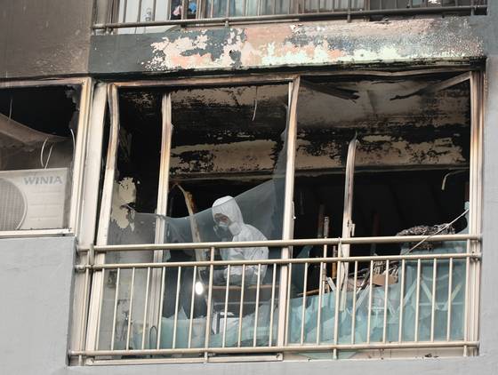 24일 오전 어린이 2명이 숨지고 다친 부산진구의 한 아파트 화재 현장에서 소방당국과 경찰 등 관계 기관이 합동감식을 벌이고 있다. 이날 오전 4시 15분께 한 아파트 4층에서 부모가 일을 나간 사이 불이 나 10살 언니가 숨지고 7살 동생이 중태에 빠지는 사고가 일어났다. 사진 연합뉴스