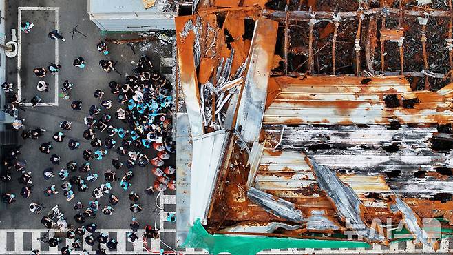 [화성=뉴시스] 김종택 기자 = 24일 경기 화성시 전곡리 아리셀 참사 화재현장에서 열린 '아리셀 참사 1주기 현장 추모 위령제'에서 유가족과 참석자들이 참사 현장에 헌화하고 있다. (공동취재) 2025.06.24. photo@newsis.com