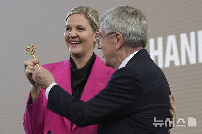 [로잔=AP/뉴시스]국제올림픽위원회(IOC) 신임 위원장으로 취임한 커스티 커번트리가 23일(현지 시간) 스위스 로잔 올림픽 하우스에서 열린 IOC 위원장 이취임식에서 전임 위원장인 토마스 바흐에게 올림픽 하우스 열쇠를 넘겨받고 있다. 2025.06.23.