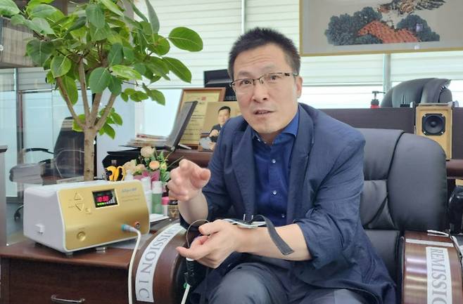 이번 연구에 사용된 리미션을 개발한 아디포랩스 한성호 대표가 고주파 온열치료 원리를 기자에게 설명하고 있다. 그는 "현재 대부분은 국내 요양병원에서 비급여로 사용되고 있다"면서 "화상이나 근육 손상 부작용 없이 체온