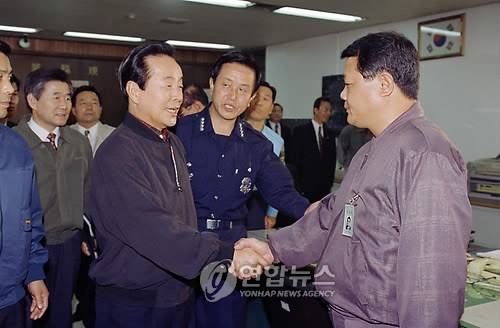 1994년 당시 김영삼 대통령이 서울 서초경찰서를 방문, 지존파 사건의 범인들을 검거한 고병천 경위를 격려하는 모습. 연합뉴스