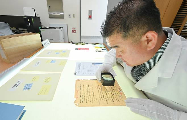 6·25전쟁 기록물 4만여점 복원 (서울=연합뉴스) 육군은 6·25전쟁 75주년을 맞아 국가등록문화재 제787호로 지정된 6·25전쟁 군사기록물 8만1천420점 중 복원 작업을 마친 4만422점을 충남 계룡대 육군기록정보관리단에서 공개했다고 24일 밝혔다. 사진은 복원 관계관이 확대경을 이용해 보존 기록물의 손상도를 확인하는 모습 [육군 제공, 재판매 및 DB 금지] 2025.6.24