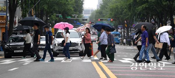 비가 내린 25일 오후 수원역 인근 횡단보도에서 우산을 쓴 시민들이 발걸음을 재촉하고 있다. 2025.6.25 /최은성기자 ces7198@kyeongin.com