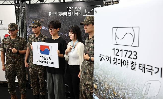 25일 서울 중구 서울역 대합실에 마련된 '태극기 부스'에서 군인들과 시민들이 태극기 배지를 패용 후 기념촬영 하고 있다.  2025.6.25/뉴스1 ⓒ News1 김도우 기자