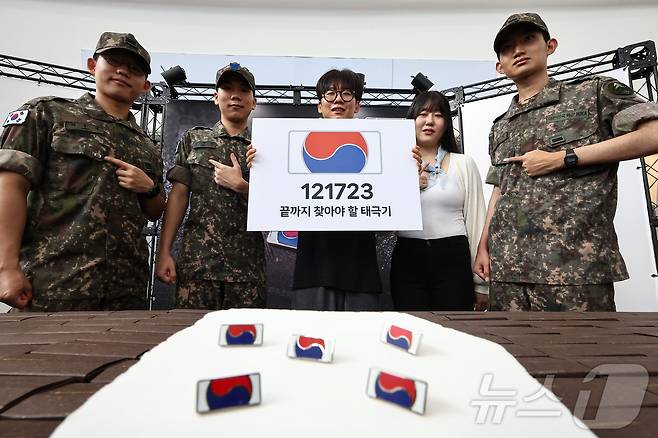 25일 서울 중구 서울역 대합실에 마련된 '태극기 부스'에서 군인들과 시민들이 태극기 배지를 패용 후 기념촬영 하고 있다.  2025.6.25/뉴스1 ⓒ News1 김도우 기자