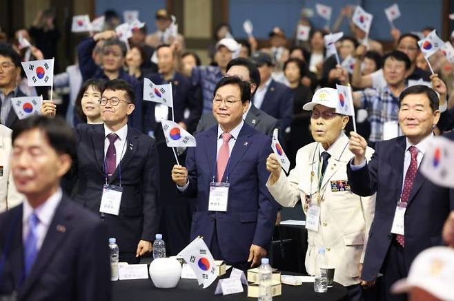 박완수 경남도지사(가운데)가  6·25전쟁 제75주년 행사에서 참전용사와 함께 태극기를 흔들고 있다. 경남도 제공