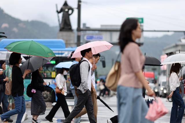 서울에 약한 비가 오락가락 이어지고 있는 25일 서울 세종로사거리에서 시민들이 길을 걷고 있다. 연합뉴스