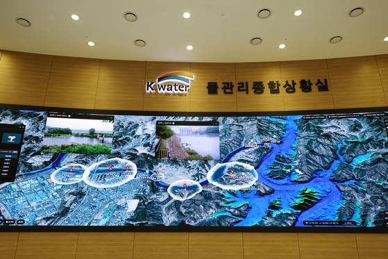 K-water(한국수자원공사) 물종합상황실에서 디지털 트윈 기술을 활용해 댐 시설 및 관련 하천 상황을 모니터링하고 있다. 가상 시뮬레이션 과정에서 대청댐 방류로 하천 수위가 상승하자 홍수 위험을 알리는 경보 시스템이 작동하고 있다. 사진 K-water