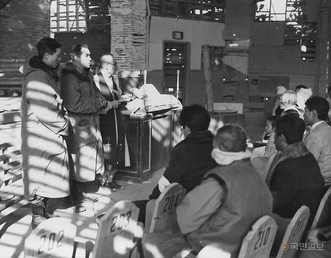 공산주의자들의 박해로 예배가 중단된 하갈 우리장로교회 성도들이 3년 만에 다시 예배를 드리는 모습. 1910년 캐나다 선교사들이 설립한 이 교회는 장진호 전투 중이던 1950년 11월, 종을 복원하고 첫 예배를 재개했다. 미 해병 제7해병연대 소속 목사 존 H. 크레이븐 중령이 통역사를 통해 한국인 이인섭 목사와 대화하는 장면을 미 해병대 L.S. 스나이더 대위가 촬영했다. WPF 안재철 대표 제공.