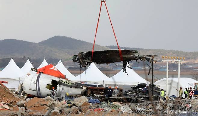 (무안=뉴스1) 박지현 기자 = 15일 오후 전남 무안국제공항 여객기 참사 현장에서 절단된 기체동체 잔해물이 공중에 들어올려 지고 있다. 2025.1.15/뉴스1  Copyright (C) 뉴스1. All rights reserved. 무단 전재 및 재배포,  AI학습 이용 금지. /사진=(무안=뉴스1) 박지현 기자