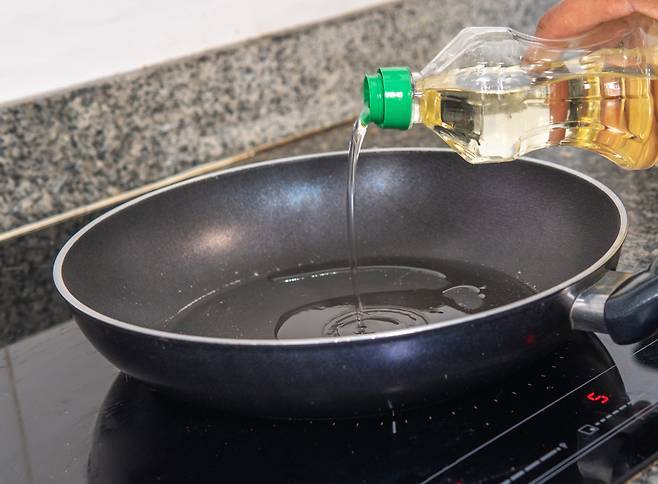 식용유를 프라이팬에 따르고 있다.[123rf]