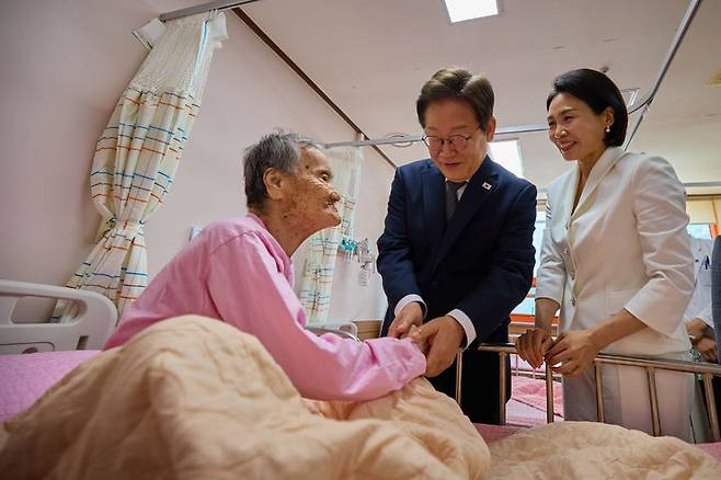 [서울=뉴시스] 이재명 대통령과 부인 김혜경 여사가 25일 전남 고흥 국립소록도병원을 찾아 환우 어르신의 손을 잡고 위로하고 있다. (사진=대통령실 제공) 2025.06.25. photo@newsis.com *재판매 및 DB 금지