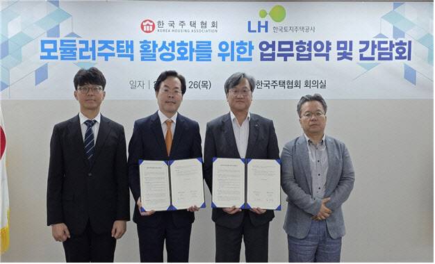 오주헌 LH 공공주택본부장(오른쪽 두번째)과 김재식 한국주택협회 상근부회장(왼쪽 두 번째) 및 관계자 등이 26일 서울 강남구 건설회관에서 모듈러주택 활성화를 위한 업무협약을 체결하고 기념 촬영을 하고 있다.(출처: LH)