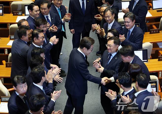 이재명 대통령이 26일 취임 이후 첫 추가경정예산안 시정연설을 위해 서울 여의도 국회 본회의장으로 입장하며 의원들과 인사나누고 있다. 2025.6.26/뉴스1 ⓒ News1 국회사진기자단