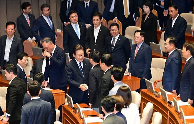 이재명 대통령이 26일 국회 본회의장에서 추가경정예산 시정연설을 마친 뒤 국민의힘 의원들과 악수하고 있다. 연합뉴스