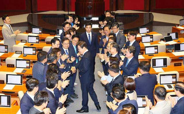 이재명 대통령이 26일 취임 뒤 첫 추가경정예산 시정연설을 위해 국회 본회의장에 입장하면서 더불어민주당 의원들과 악수를 하고 있다. 대통령실사진기자단