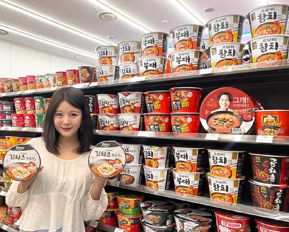 GS25에서 모델이 '오모리김치즈볶음면'을 소개하고 있다. [사진=GS25]