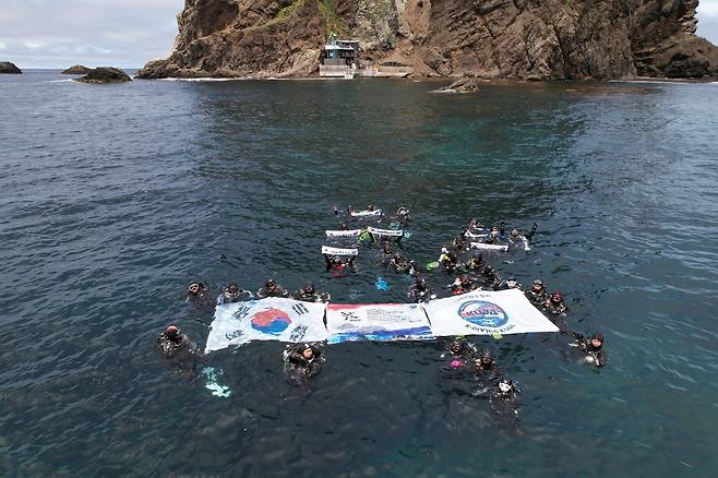 지난 15일 독도 수중 정화 활동에 앞서 참가자들이 태극기를 들고 기념 촬영을 하고 있다. 대한잠수협회 제공