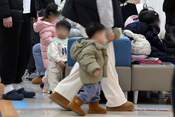 Children and their parents wait for treatment at a pediatric hospital in Seoul on Jan. 13. [NEWS1]