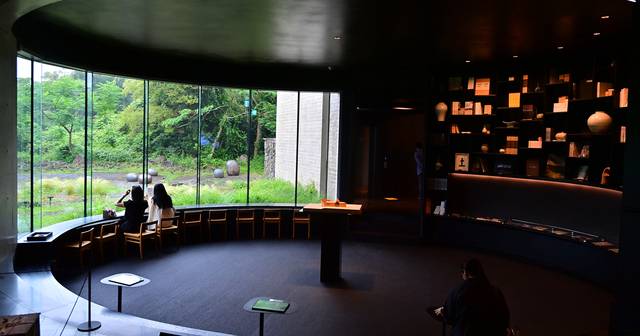 유동룡미술관(이타미 준)의 1층 서재 공간. 곡면의 창이 제주 특유의 빌레(암반) 정원의 숲을 마치 영화관 스크린처럼 보여준다.