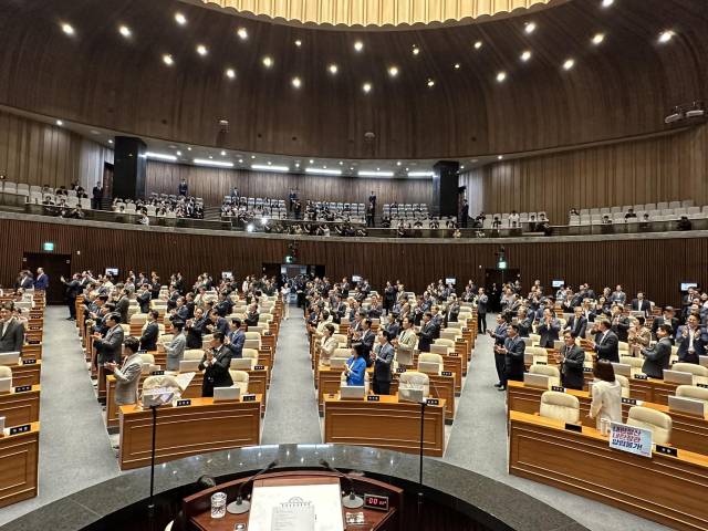 ▲26일 시정연설을 마친 이재명 대통령이 야당의석으로 가 악수를 하는 동안 여당의원들이 모두 일어나 야당의석 쪽을 바라보며 박수를 치고 있다. ⓒ우원식 국회의장 SNS