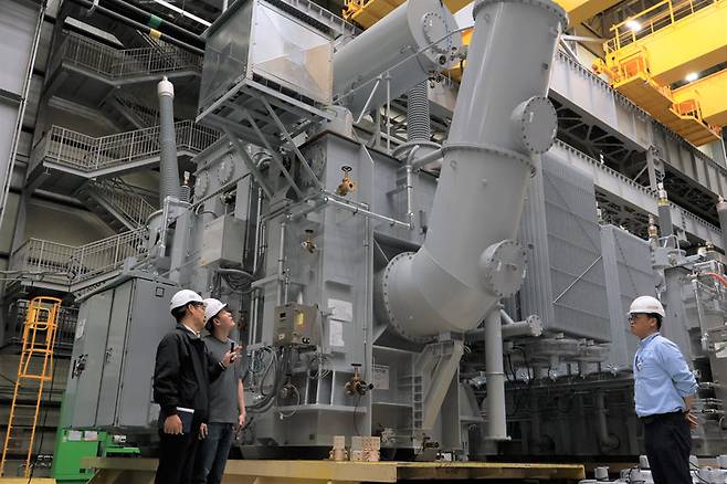 강진호 HD현대일렉트릭 앨라배마 법인장(왼쪽)이 미국 현지 공장에서 만들어진 154kV(킬로볼트)급 대형 변압기에 대해 설명하고 있다. HD현대일렉트릭은 지난해 미국 내 대형 변압기 시장 점유율 15%를 달성하며 1위에 올랐다. HD현대일렉트릭 제공