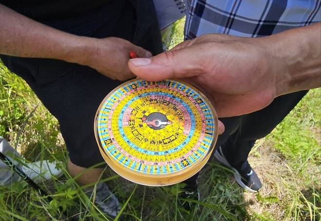 지난 15일 세종시 국무총리 공관 근처 원수산 아래 있는 ‘대통령 제2집무실 후보지’를 찾은 대한풍수지리학회 회원들이 풍수나침반으로 해당 부지의 방향을 확인하고 있다. 나침반의 바늘은 ‘임자 병향’을 가리켰고, 지종학 대한풍수지리학회장은 “정남향이란 뜻”이라고 설명했다. 최예린 기자