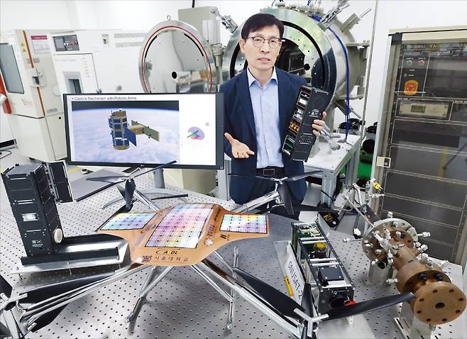 김종암 서울대 항공우주신기술연구소 소장이 올해 말 누리호 4차 발사에 탑재될 큐브위성 SNUGLITE-Ⅲ를 손에 들고 이 위성의 임무인 랑데부 도킹에 대해 설명하고 있다. 앞에는 이 연구소가 자체 개발한 화성 탐사용 회전익 드론, 뒤쪽엔 우주열환경 모사장치. /이솔 기자